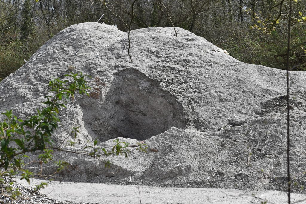 Plastic dust from abandoned uPVC waste piles spreading into the surrounding environment.
